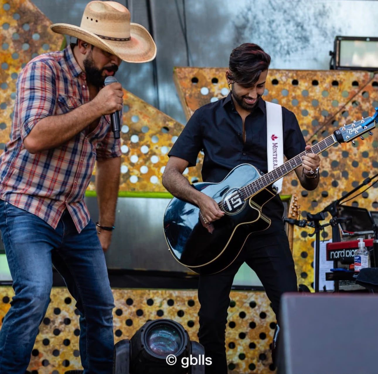 Euller tocando violão no palco ao lado de Fernando